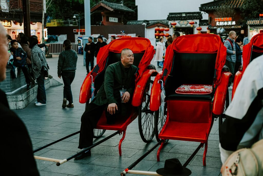Bustling scene of rickshaws and people in Nanjing, showcasing vibrant cultural street life.