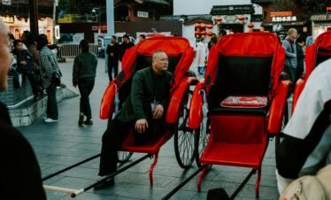 Bustling scene of rickshaws and people in Nanjing, showcasing vibrant cultural street life.
