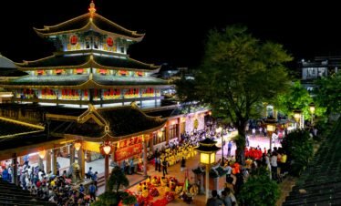 Brightly lit pagoda during a traditional festival in An Giang, Vietnam, showcasing cultural and architectural beauty.