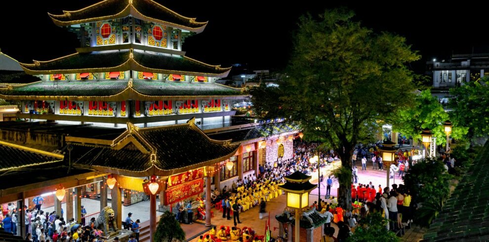 Brightly lit pagoda during a traditional festival in An Giang, Vietnam, showcasing cultural and architectural beauty.