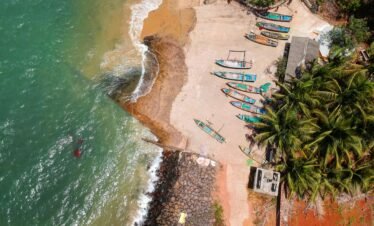 Stunning aerial view of colorful boats along the tropical Malvan beach in Goa, India.