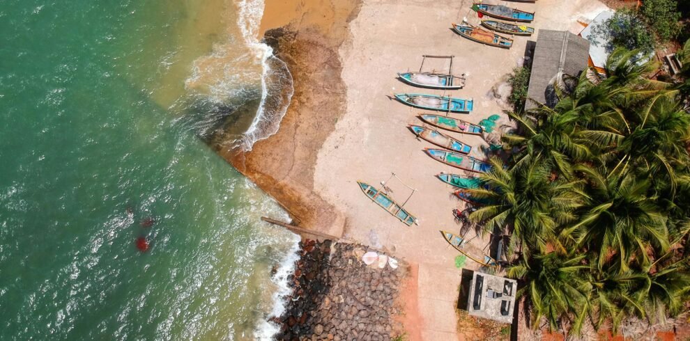 Stunning aerial view of colorful boats along the tropical Malvan beach in Goa, India.