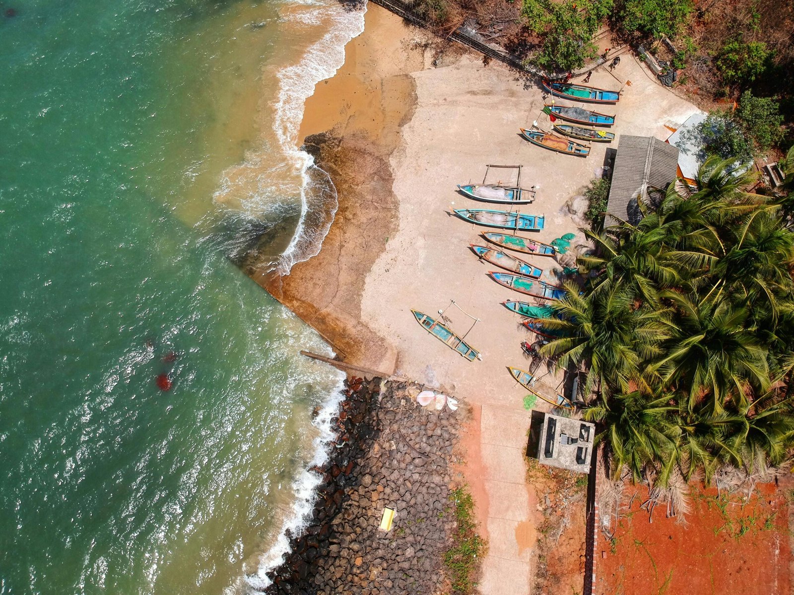 Stunning aerial view of colorful boats along the tropical Malvan beach in Goa, India.