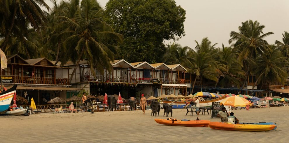 Relaxing beachfront with colorful kayaks, palm trees, and vibrant outdoor seating in tropical setting.
