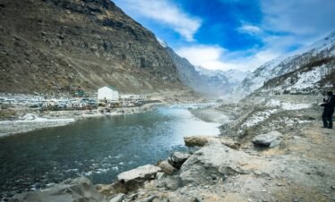 Stunning landscape of Beas River and snow-capped mountains in Manali, India.