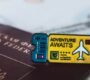 A Russian passport with an 'Adventure Awaits' pin symbolizes travel and exploration.