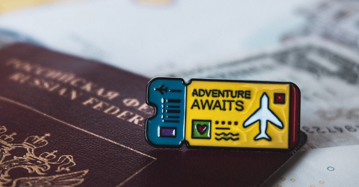 A Russian passport with an 'Adventure Awaits' pin symbolizes travel and exploration.