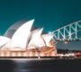 Stunning night view of Sydney Opera House and Harbour Bridge, beautifully illuminated against a clear sky.