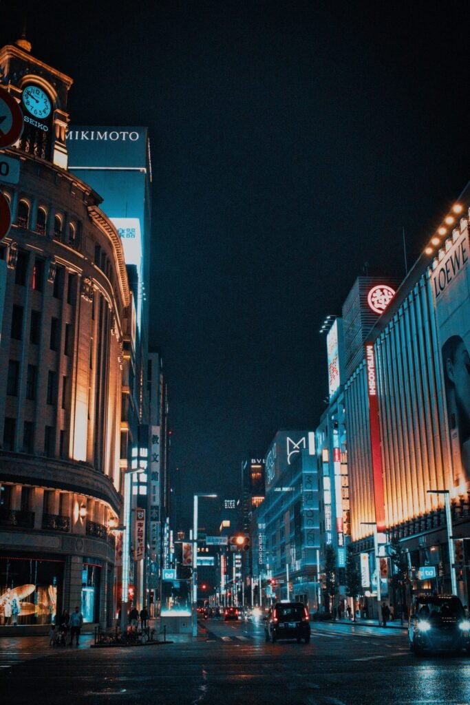 Experience the vibrant nightlife of Ginza, Tokyo, in this stunning street view illuminated by towering neon lights.