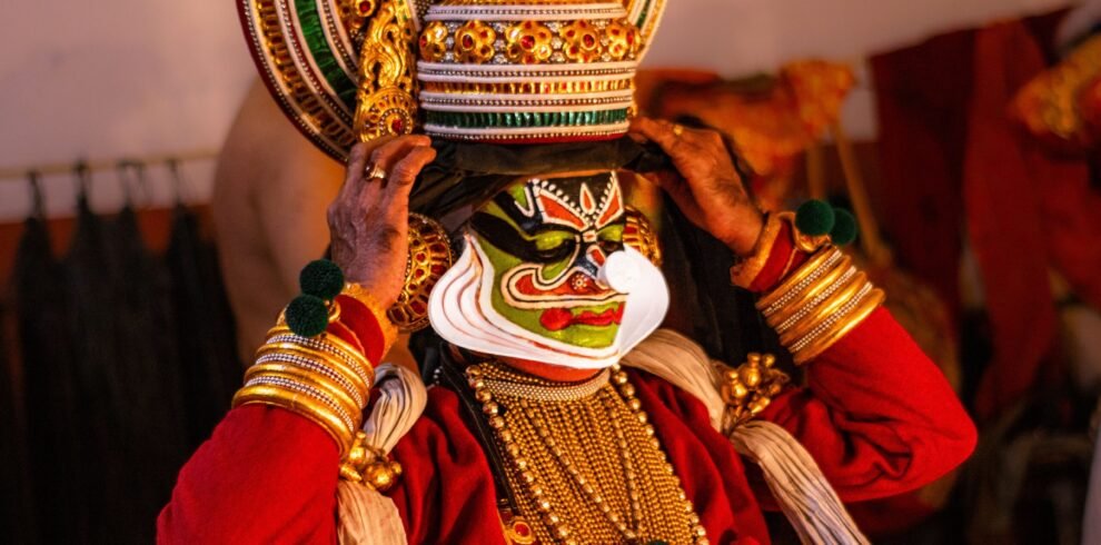 A Kathakali performer donning traditional attire and face makeup backstage, capturing the essence of Indian classical dance.