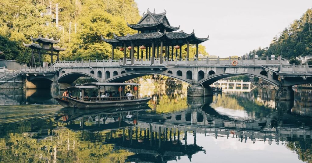 Beautiful traditional Chinese bridge over a reflective lake with lush surroundings.