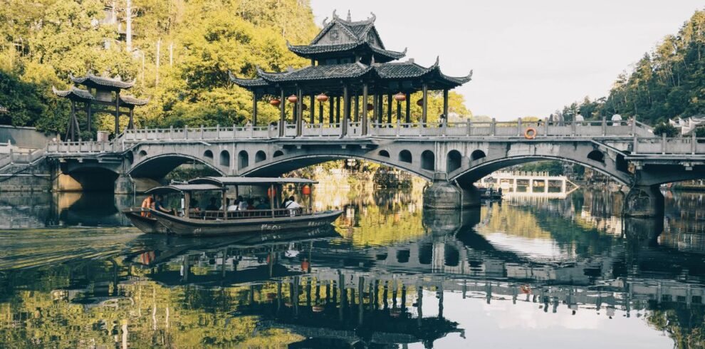 Beautiful traditional Chinese bridge over a reflective lake with lush surroundings.