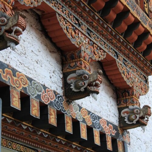Detailed view of ornate Bhutanese architecture with vibrant dragon motifs.