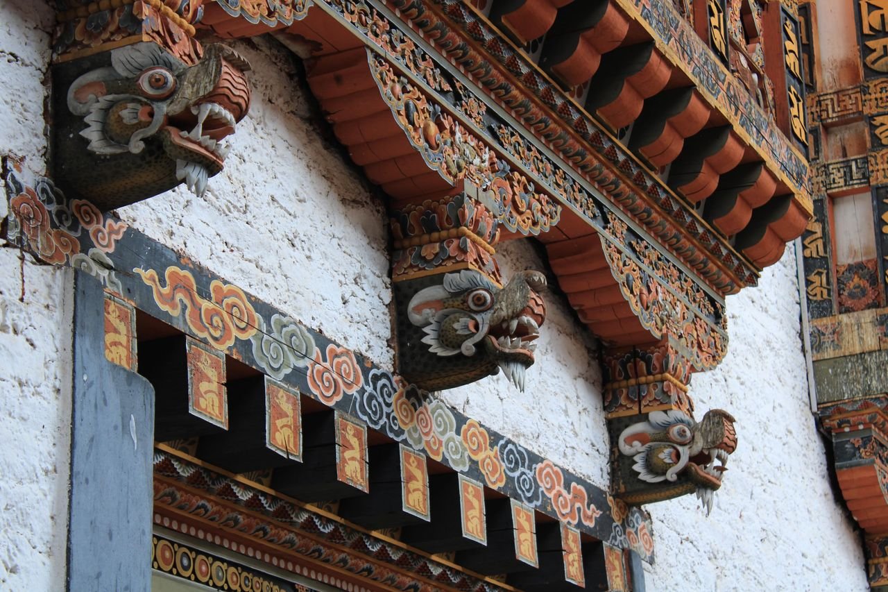 Detailed view of ornate Bhutanese architecture with vibrant dragon motifs.
