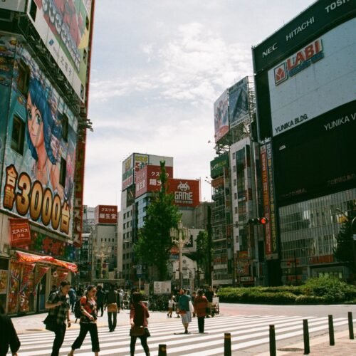 Bustling urban street in Shinjuku, Tokyo showcasing Japanese culture and vibrant billboards.