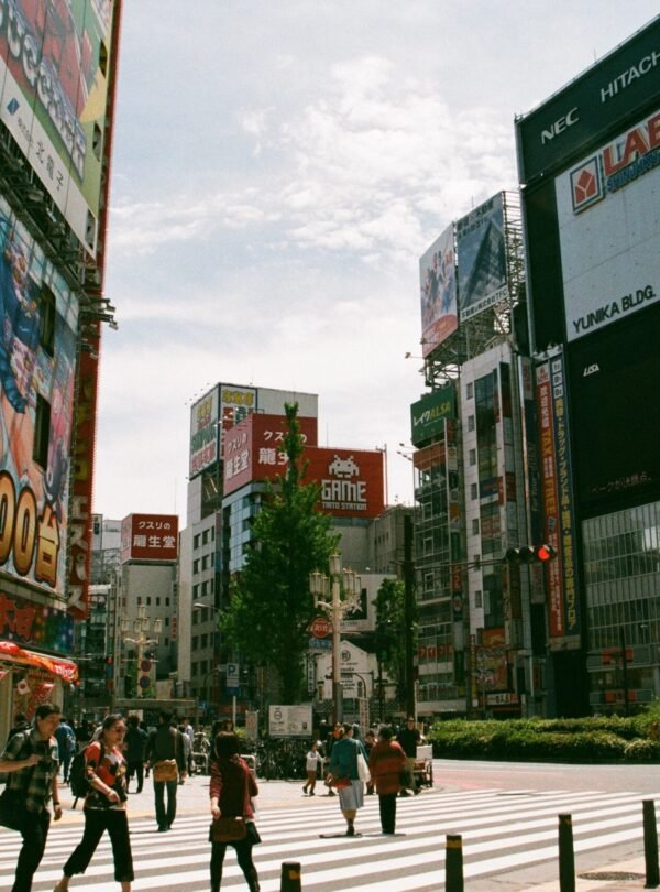 Bustling urban street in Shinjuku, Tokyo showcasing Japanese culture and vibrant billboards.