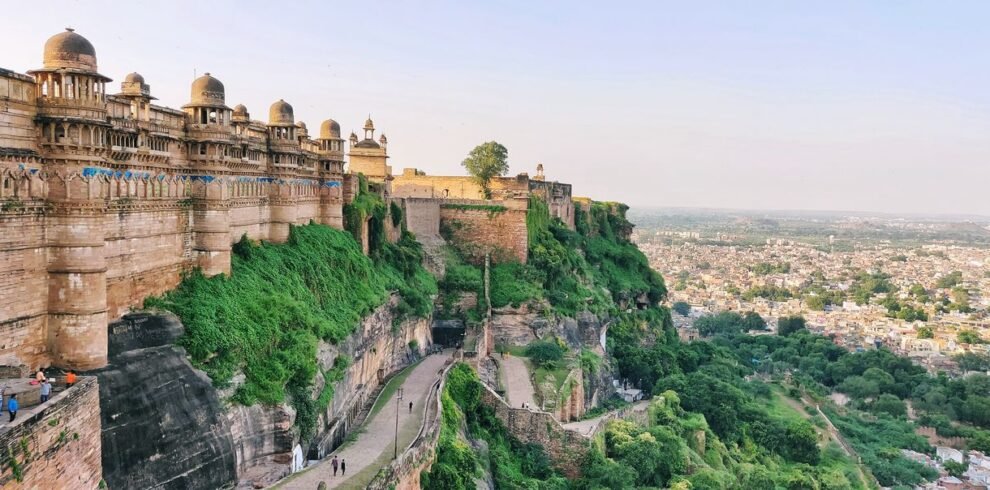 Majestic view of Gwalior Fort in India, showcasing historic architecture and lush landscape.