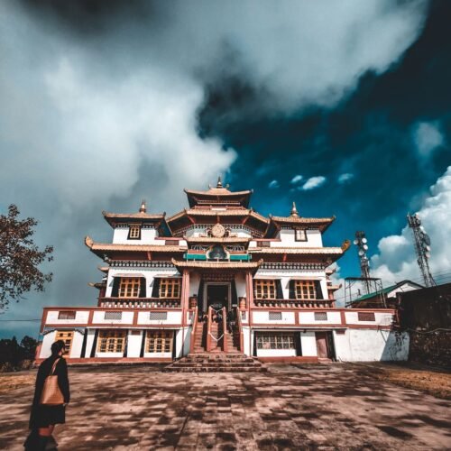 Stunning view of a traditional Buddhist monastery under dramatic clouds in Kalimpong, India.