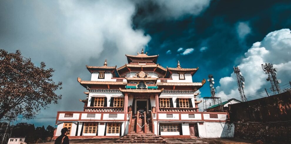 Stunning view of a traditional Buddhist monastery under dramatic clouds in Kalimpong, India.