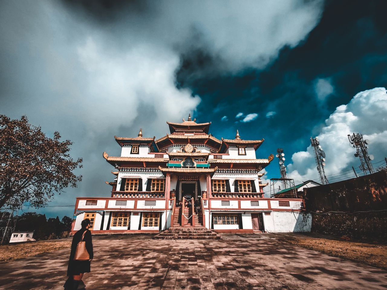 Stunning view of a traditional Buddhist monastery under dramatic clouds in Kalimpong, India.