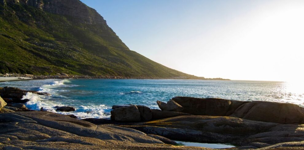 Tranquil coastal landscape of a rocky shore with mountains in South Africa.